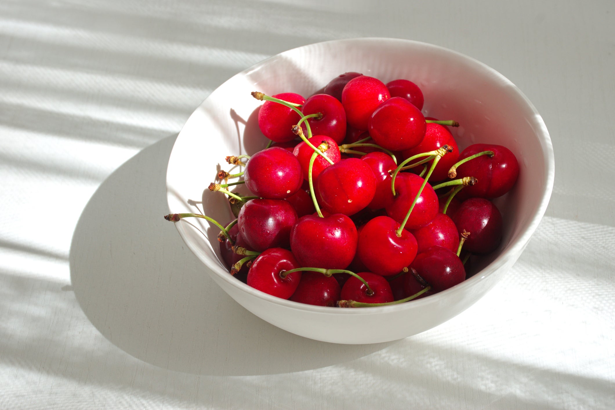 High Angle View Of Cherries In The Bowl Against The White Background