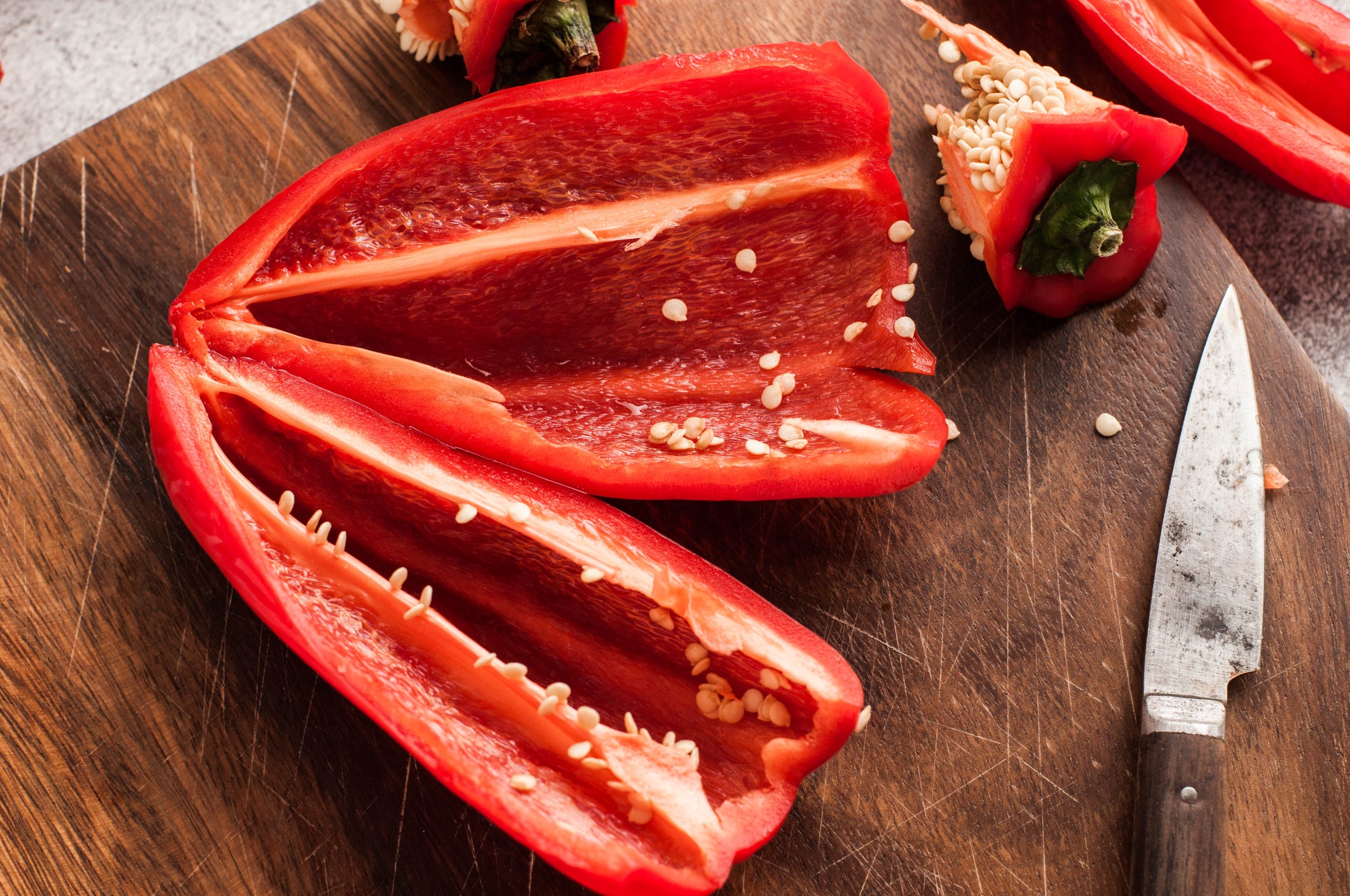 A slice of red bell pepper on a cutting board