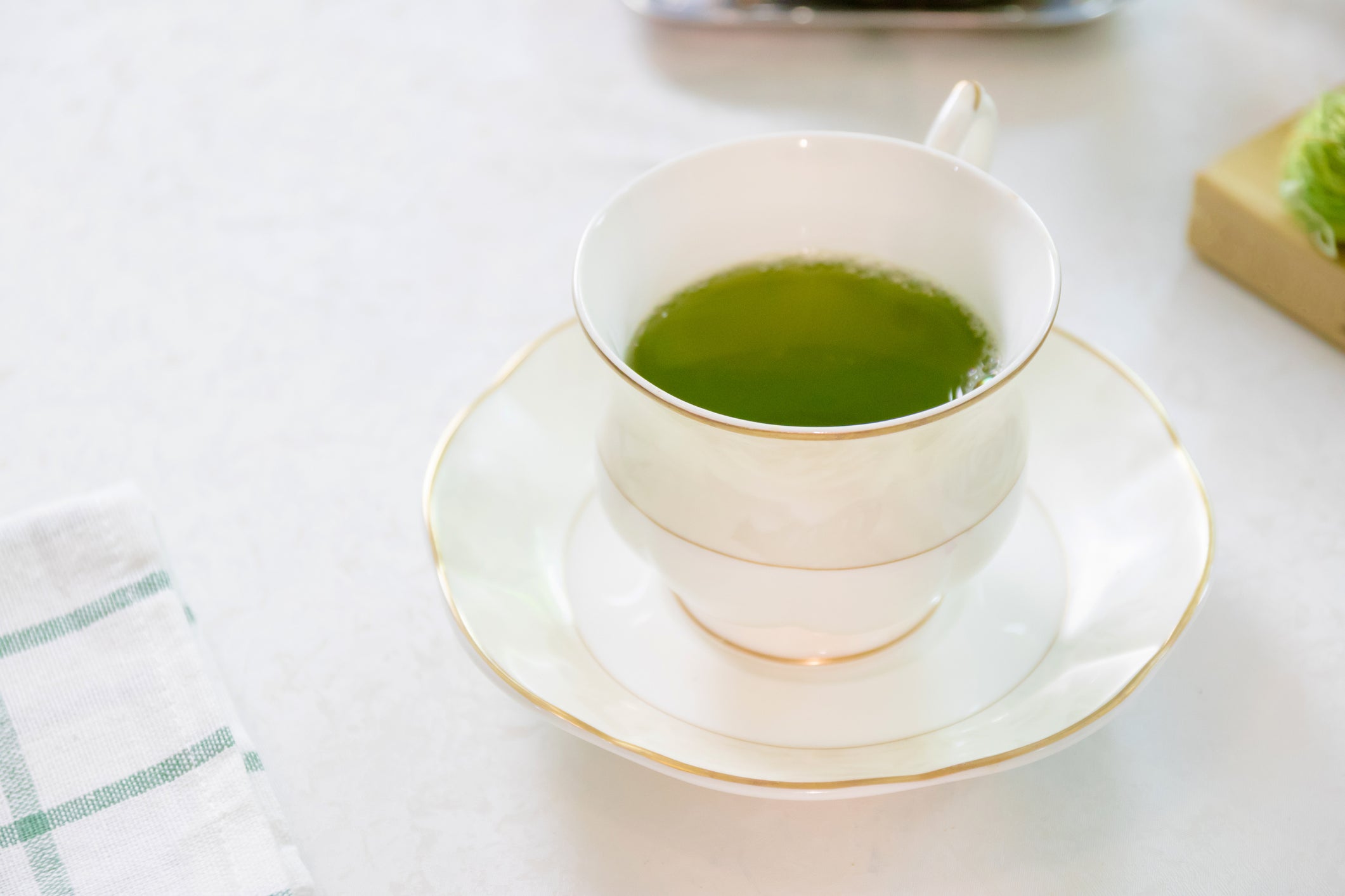 Porcelain cup of green tea on table in afternoon.