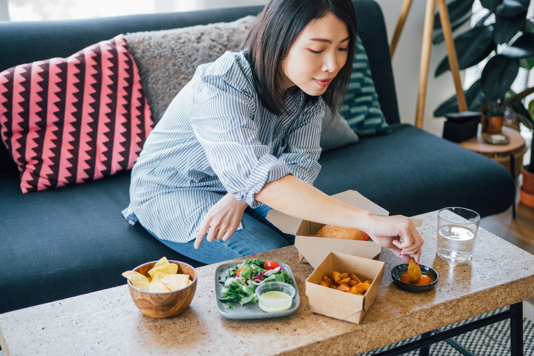 Young Woman Eating Fast Food At Home