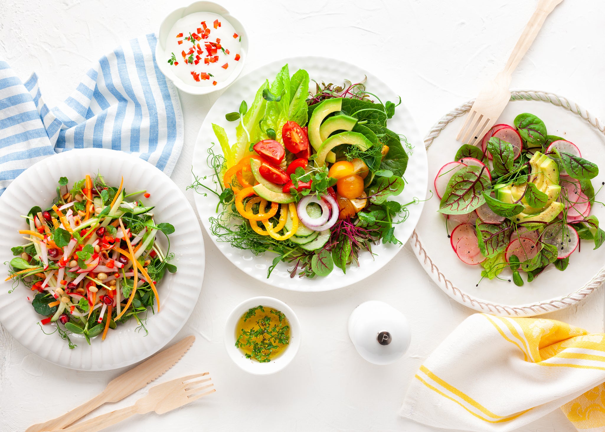 Various healthy salads of fresh vegetables,fruits and microgreens on table.