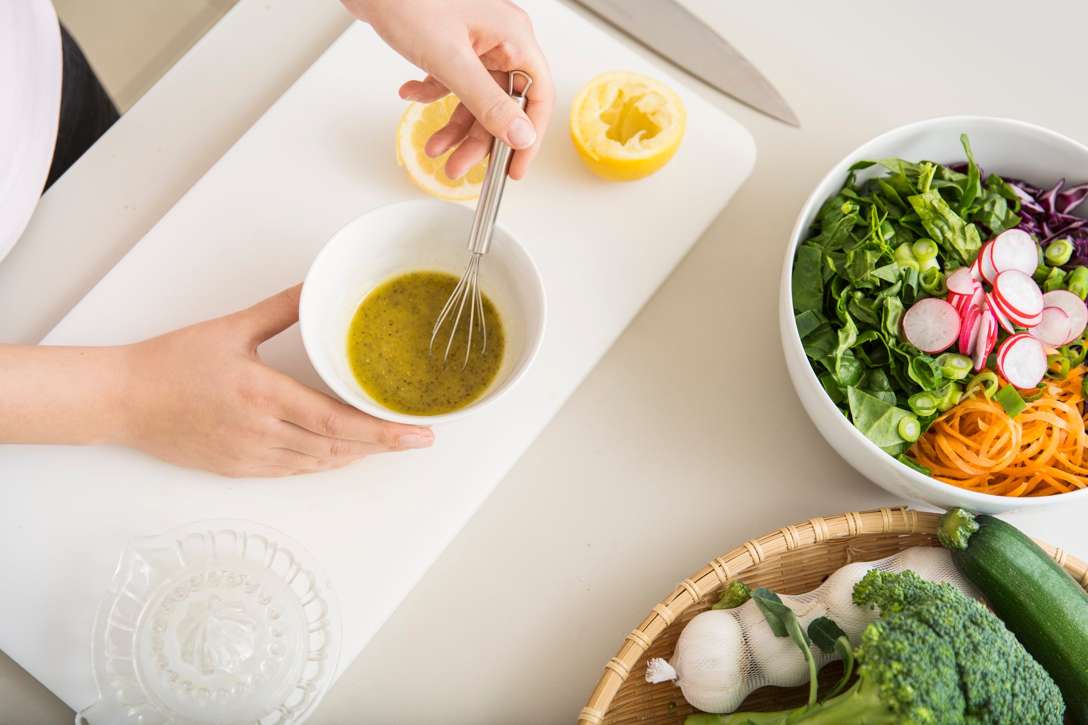 Young woman preparing a fresh salad dressing