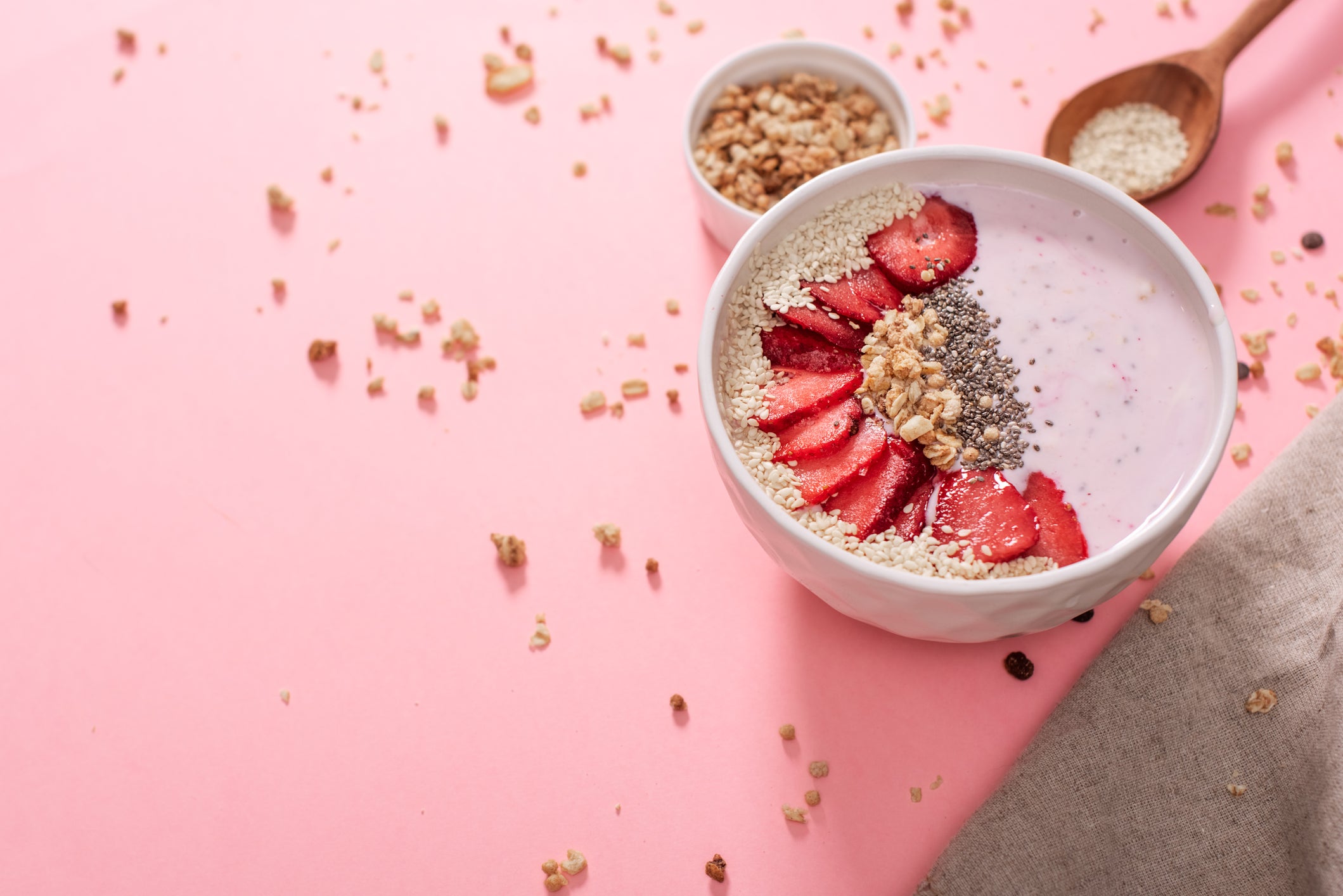 A bowl of healthy and delicious strawberry smoothie with grains and fresh fruit.