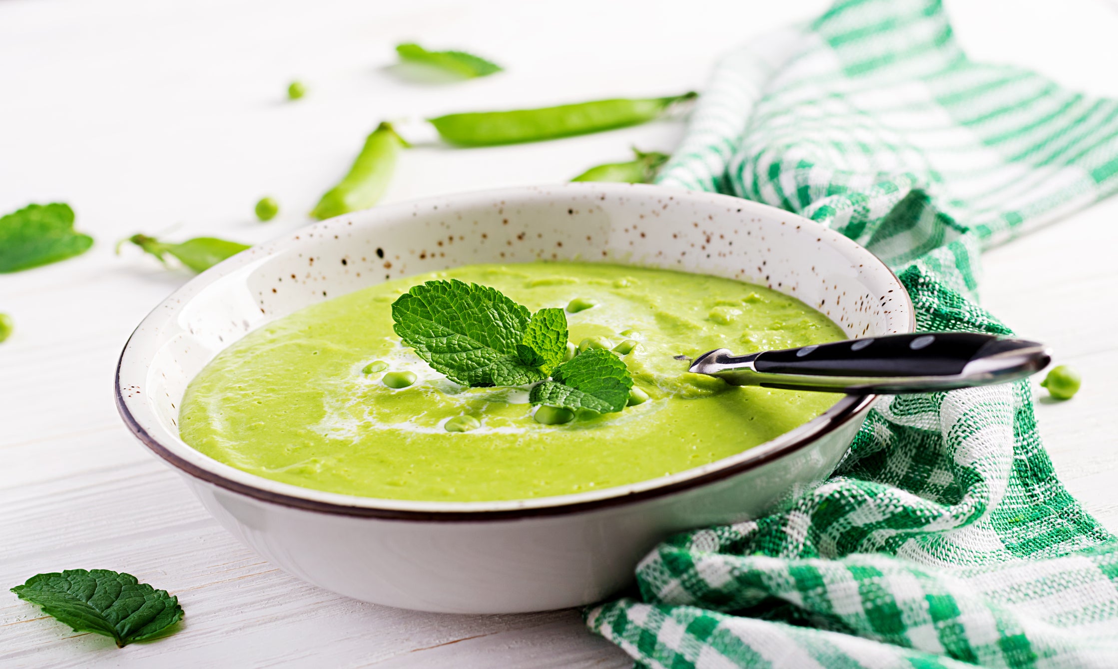 Green pea soup in bowl on wooden table. French cuisine.